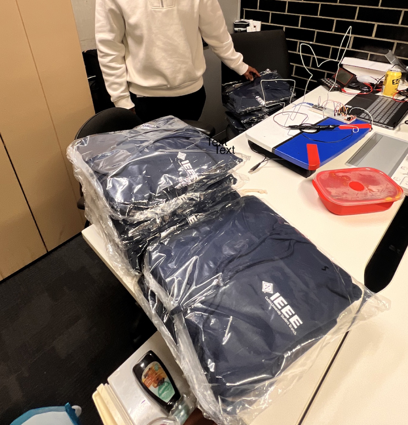 Stacks of packaged IEEE Curtin committee garments at handover