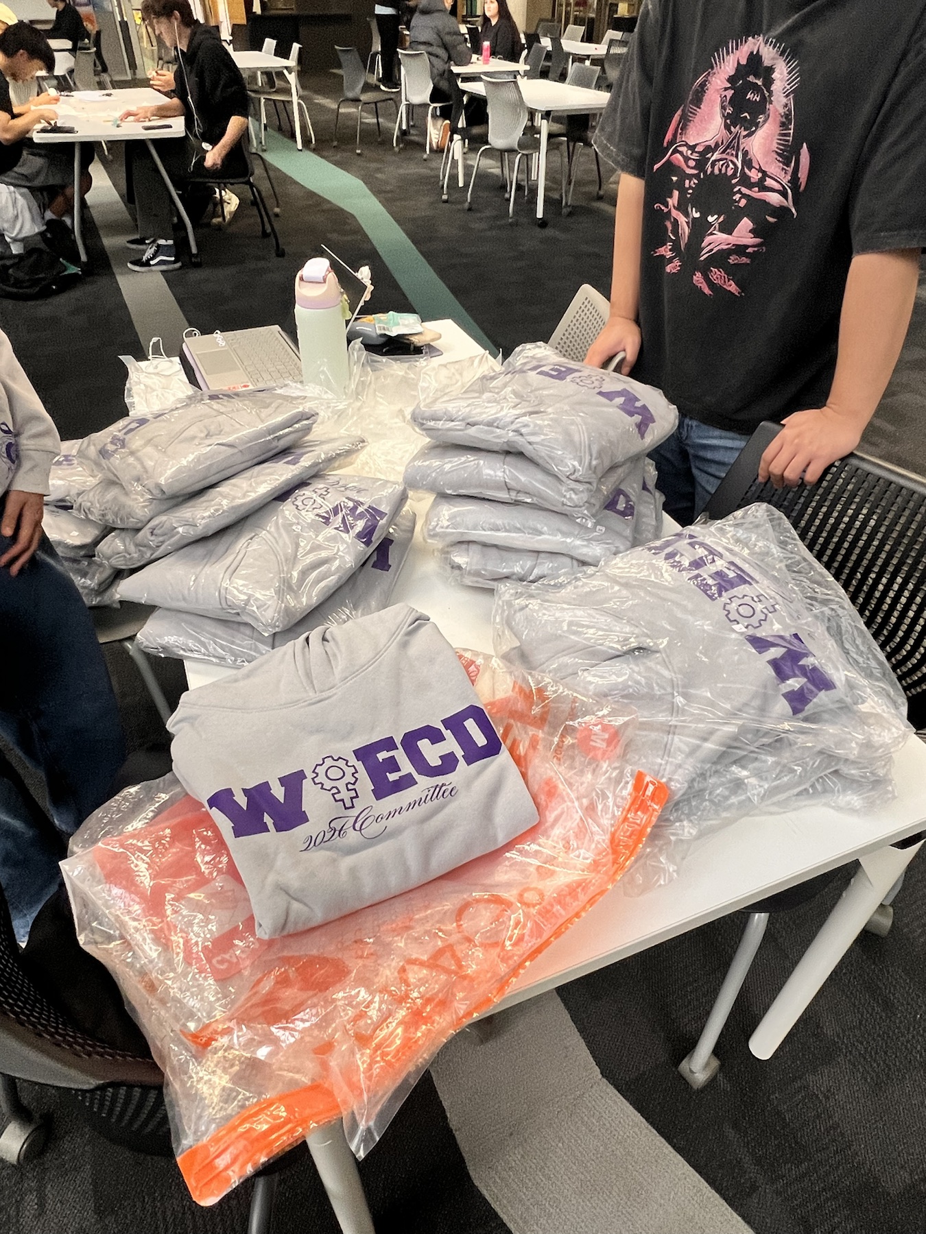 WiECD committee hoodies arranged on a table at campus handover